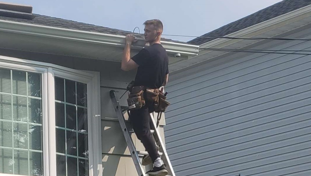 John's son working on gutter installation, representing the next generation of quality craftsmanship at Tri State Gutters