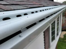 Guttershell double-drop aluminum gutter guards installed - Need: 600x400px image of Guttershell guards showing the double-drop design